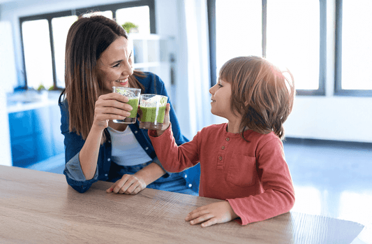 A woman and child enjoying a healthy green drink 